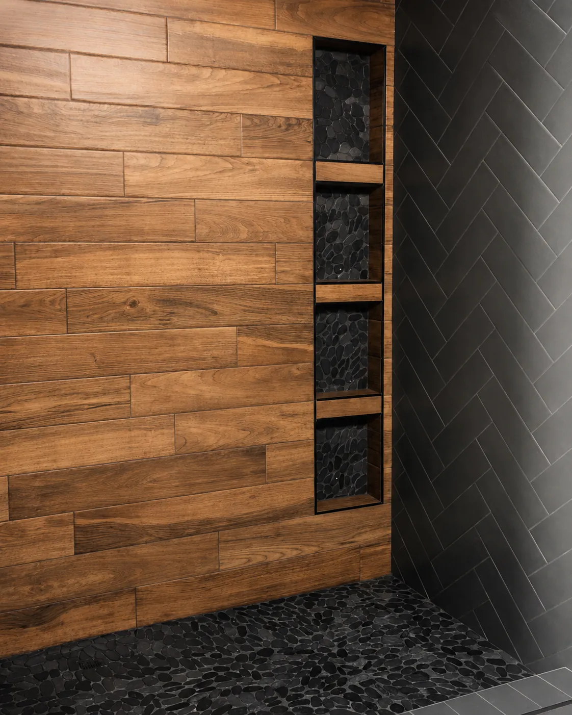 Walk-in wood-look tile shower with black niche and dark accents